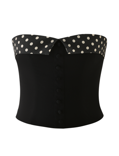 The KITTIE 2.0 BUSTIER by TIGERMIST is a black strapless corset in stretch suiting fabric, featuring a folded polka dot top edge and a front row of covered buttons.