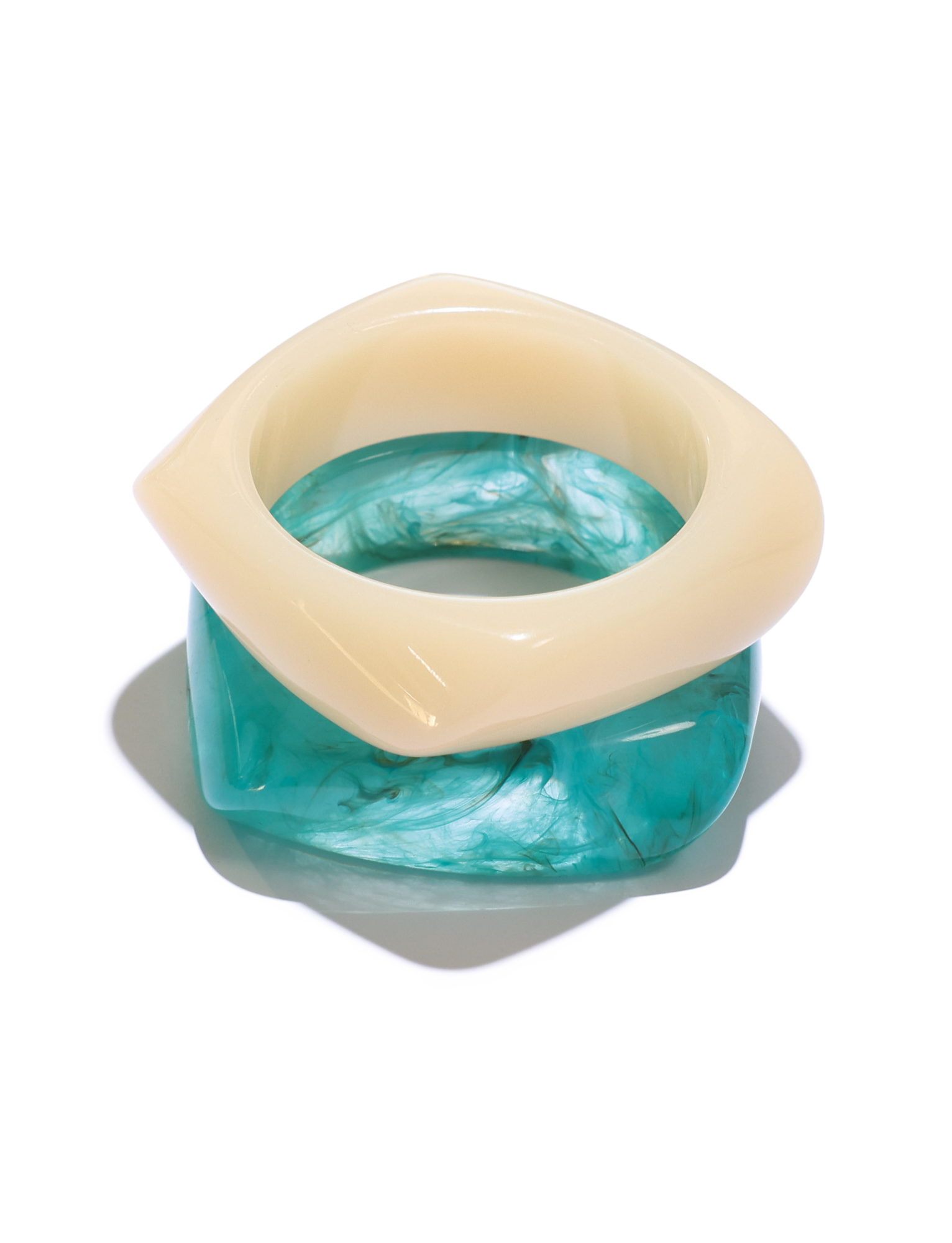 The TIGERMIST TIA CHUNKY 2PC RESIN BANGLE SET features a cream geometric bangle stacked with a square blue marble-finish bangle, both casting shadows on a white background.