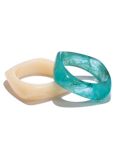 The TIGERMIST TIA CHUNKY 2PC RESIN BANGLE SET features geometric cream and blue marbled bangles shown side by side on a white background.