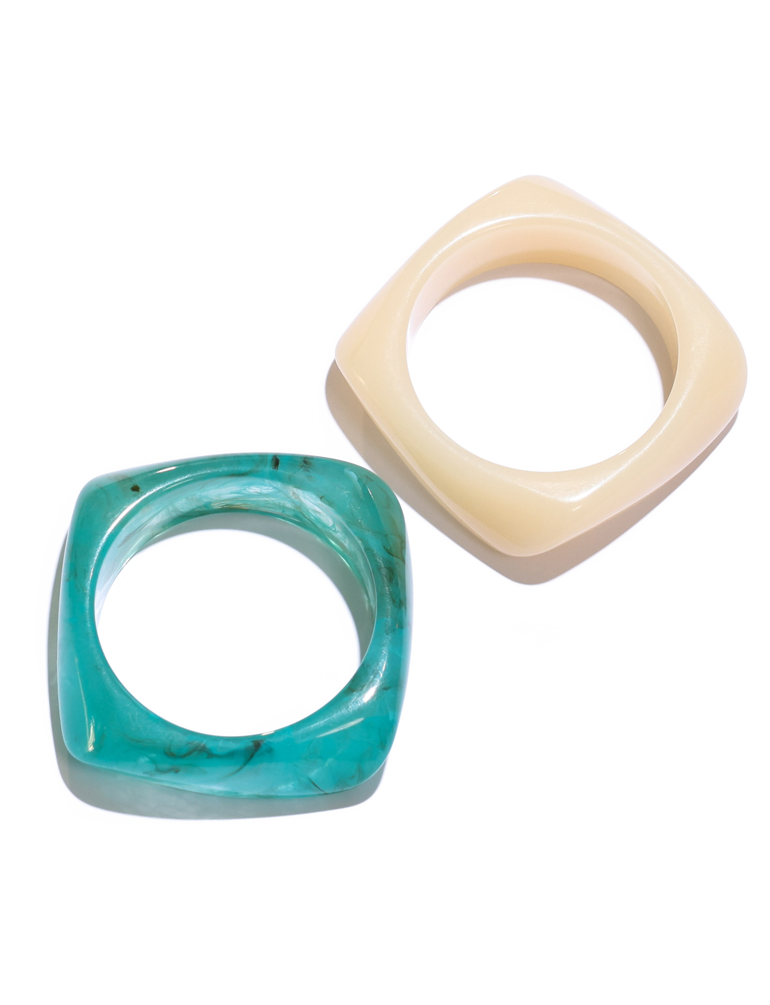 The TIGERMIST TIA CHUNKY 2PC RESIN BANGLE SET features two square-shaped bangles: one in glossy turquoise blue marble and one in solid cream, both crafted from resin and displayed on a white background.