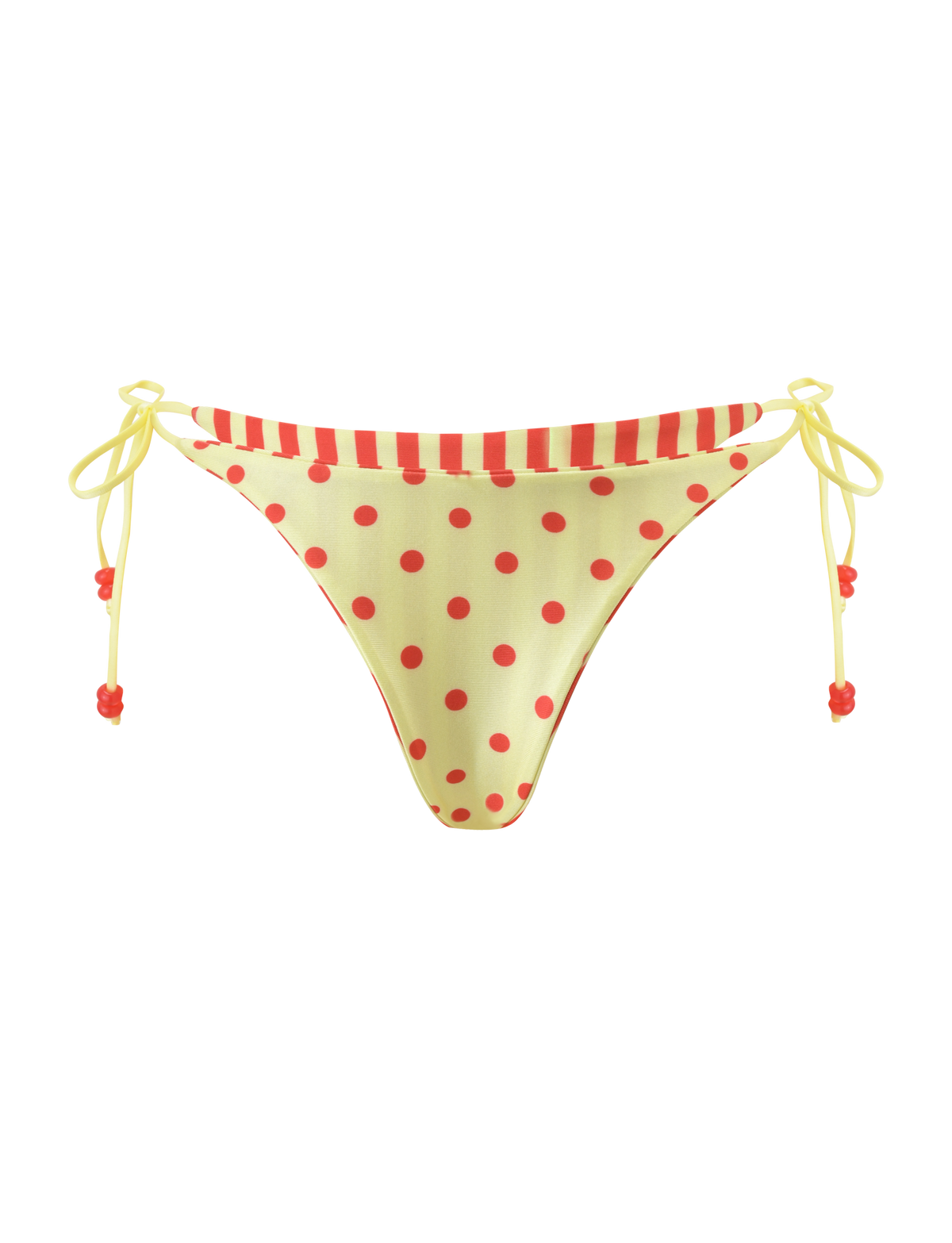 The FINLEA REVERSIBLE BIKINI BOTTOM by TIGERMIST features a cheeky cut with yellow polka dots, a red-striped waistband, and yellow side ties with red beads, shown on a plain white background.