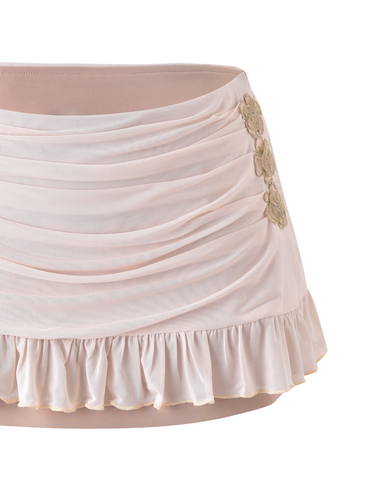 The TERESE FLORAL APPLIQUE SKIRT in tan by TIGERMIST features ruching, a ruffled hem, and three gold floral appliqués on one side, shown against a plain white background.