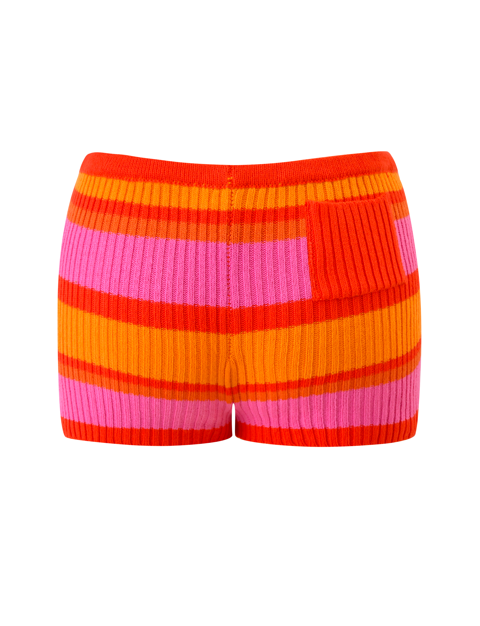 The EVERLY KNIT SHORT by TIGERMIST features high-waisted, ribbed knit fabric in sunset tropical orange, red, and pink stripes, with a small ribbed patch on the right side and an elastic waistband for a comfortable fit.