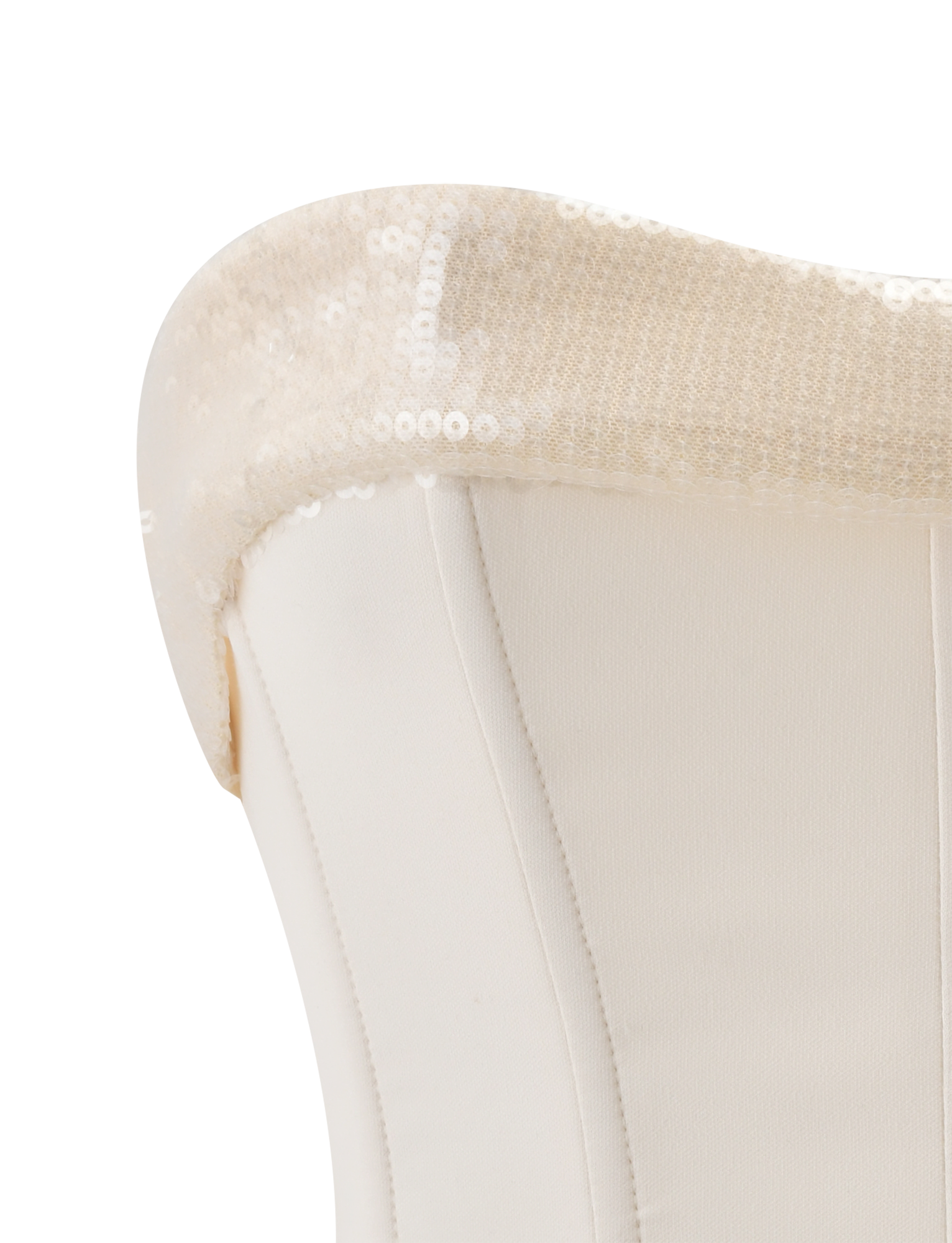 Close-up of a white upholstered chair's backrest adorned with the TIGERMIST CHARLYZE BUSTIER in cream, its sequined details draped elegantly over the top edge, evoking the refined style of a corset bustier.