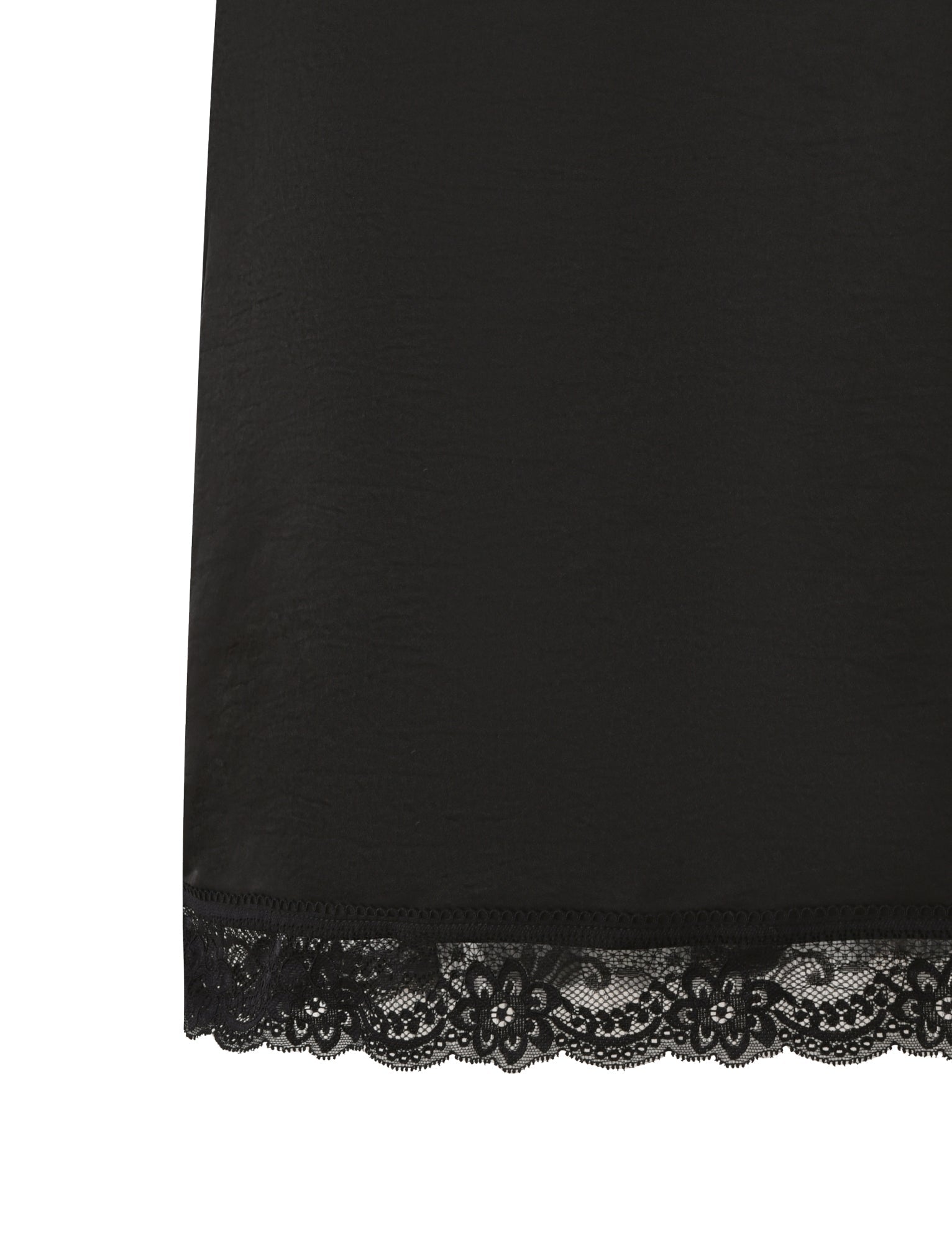 Close-up of the hem of the TIGERMIST LEISEL SKIRT in black, a midi skirt crafted from smooth satin fabrication and finished with a delicate floral lace trim along the bottom edge.