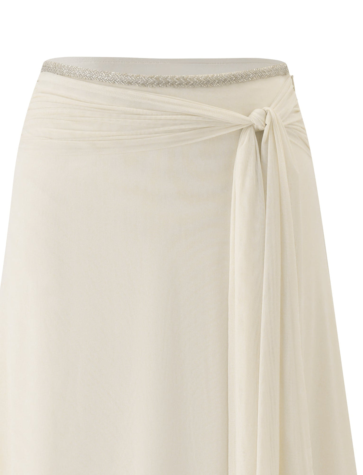 The JUNA MIDI SKIRT - CREAM by TIGERMIST is a cream-colored, flowy mesh midi skirt featuring a metallic silver waistband and an elegant side tie detail. Designed with an asymmetrical hem for added sophistication, it is showcased against a white background.
