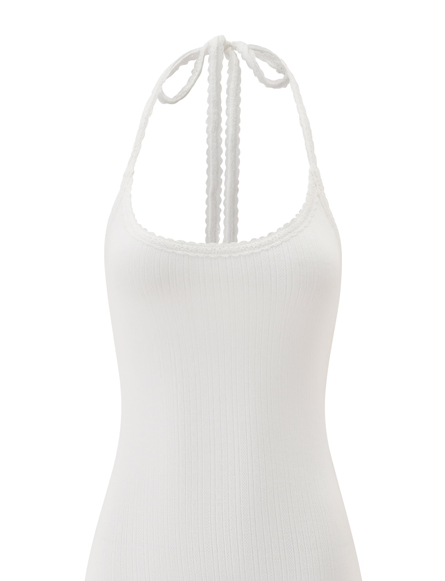 The TIPPI MINI DRESS - WHITE by TIGERMIST is a chic halter-neck mini dress with a ribbed texture, scalloped edge, and tie-back detail at the neck. The image highlights the upper portion of this delicately detailed white dress against a plain background, showcasing its fresh, modern style.
