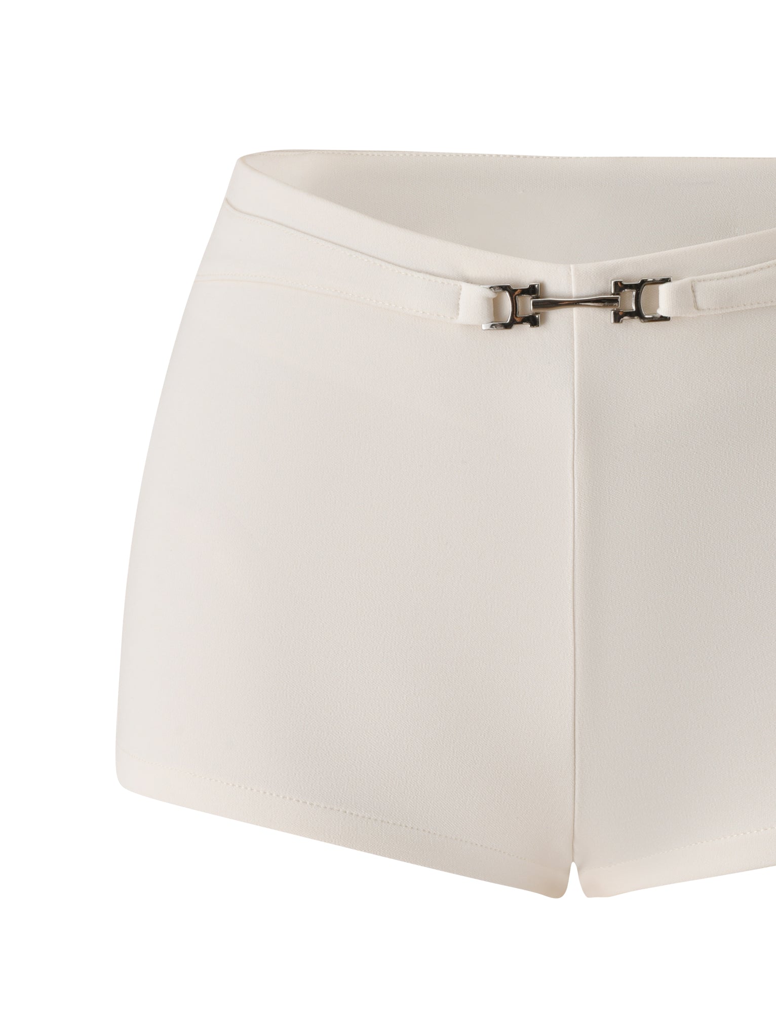 The KITTIE BUCKLE SHORT - CREAM by TIGERMIST features a white, high-waisted design with a fitted silhouette, crafted from stretch suiting fabric for a flattering fit. A slim, matching belt with a small metal buckle at the front—echoing the signature Kittie Buckle Pant—completes the look. The smooth yet slightly textured fabric adds a refined finish.