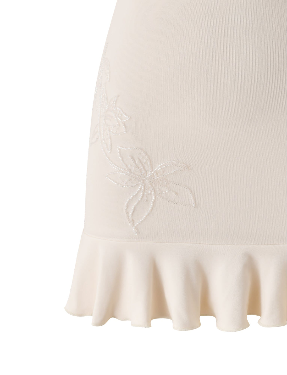 Close-up of the GIULIA MINI DRESS in ivory by TIGERMIST, featuring a cream-colored silhouette with a wavy ruffled hem and delicate floral embroidery near the edge, evoking romantic bridal shower style.