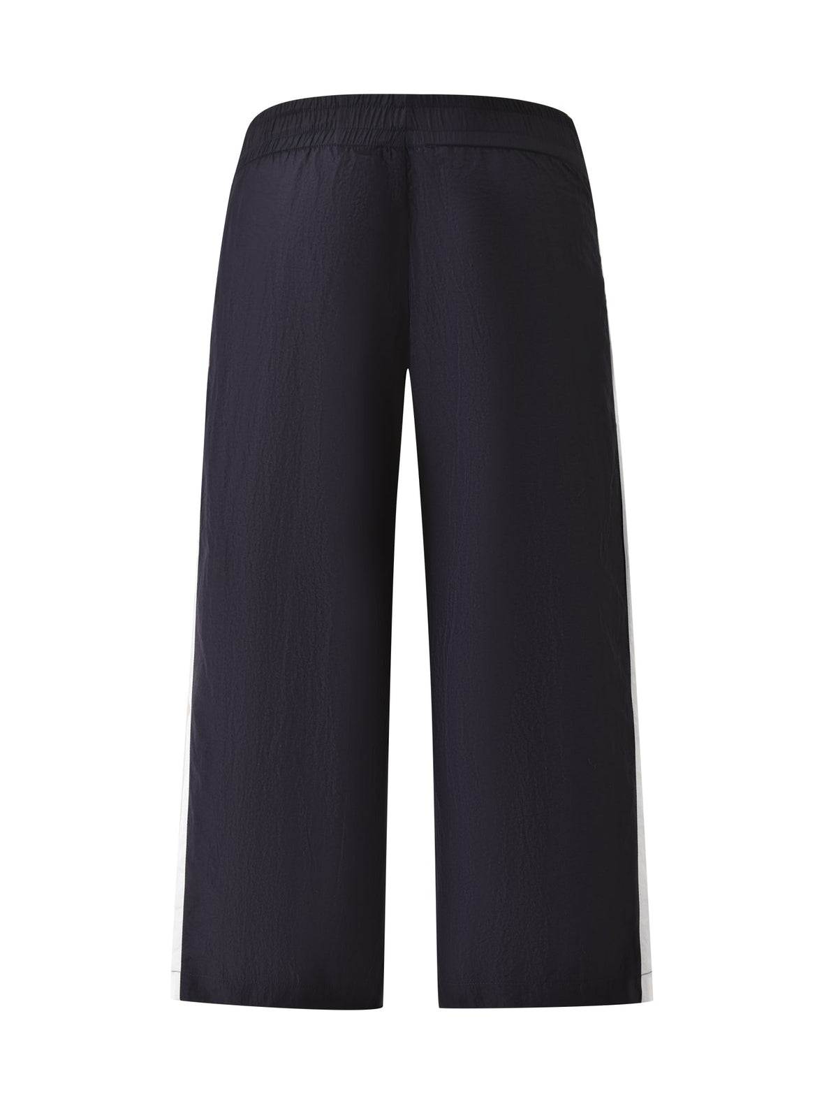 Back view of the SOPHIA WINDBREAKER CAPRI in navy and white by TIGERMIST, featuring windbreaker fabric, an elastic waistband, and wide white vertical stripes along the sides.