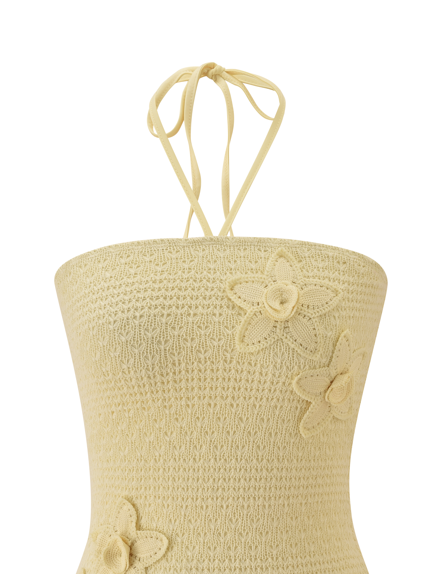 The KORRI DRESS - BUTTER by TIGERMIST features delicate crochet details and a soft beige hue, with thin neck ties and floral appliques adding texture and charm to the front.