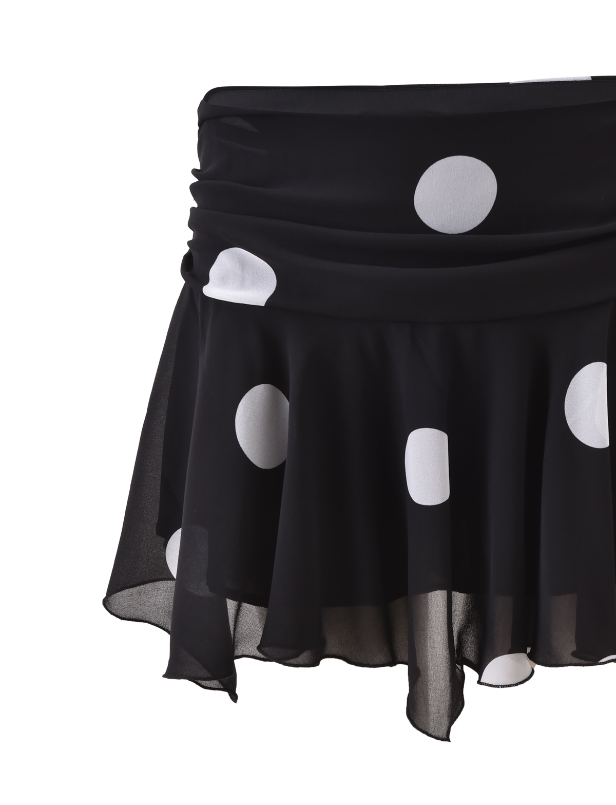 The AYDIN MINI SKIRT by TIGERMIST is a black, flowy skirt with large white polka dots, a sheer overlay, ruched waistband, and asymmetrical hem, displayed against a plain white background.