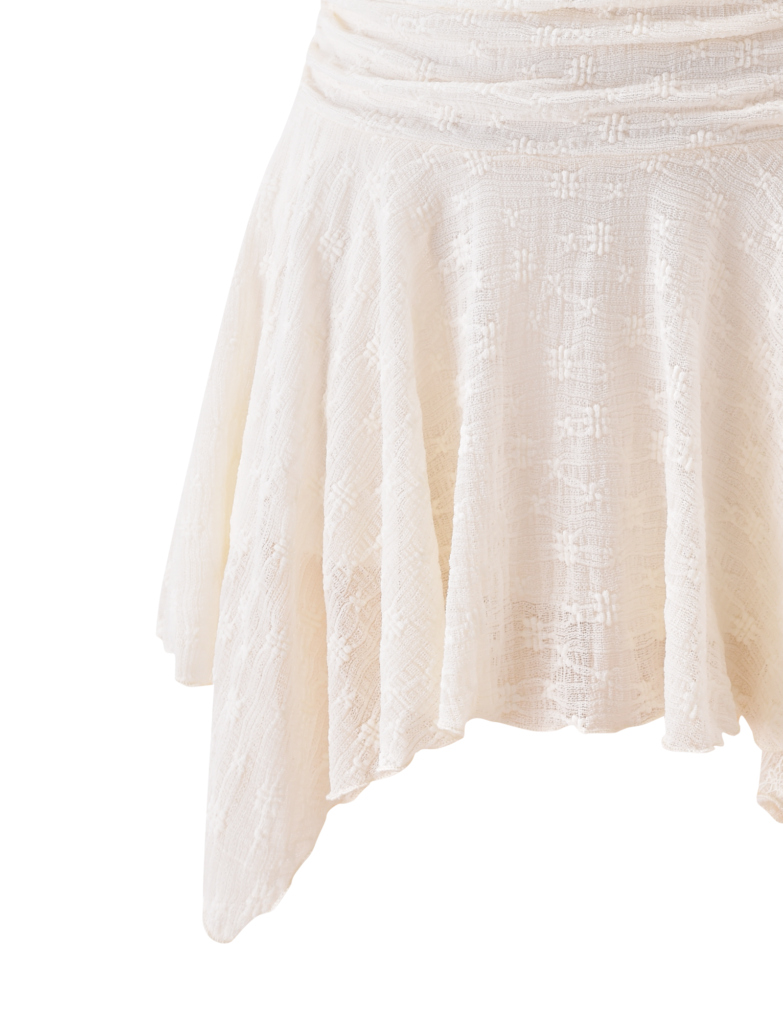 A close-up of the TIGERMIST MYLAH MINI SKIRT in ivory, featuring textured eyelet details and an asymmetrical handkerchief hem, displayed on a plain white background.