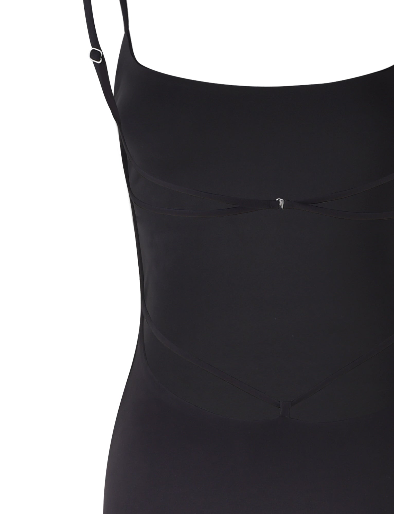 A close-up view of the MINERVA MAXI DRESS - BLACK from TIGERMIST. The top portion features thin shoulder straps and subtle black ribbon detailing near the bust area, designed to add a decorative touch. The fabric appears smooth and fitted, giving a sleek appearance.