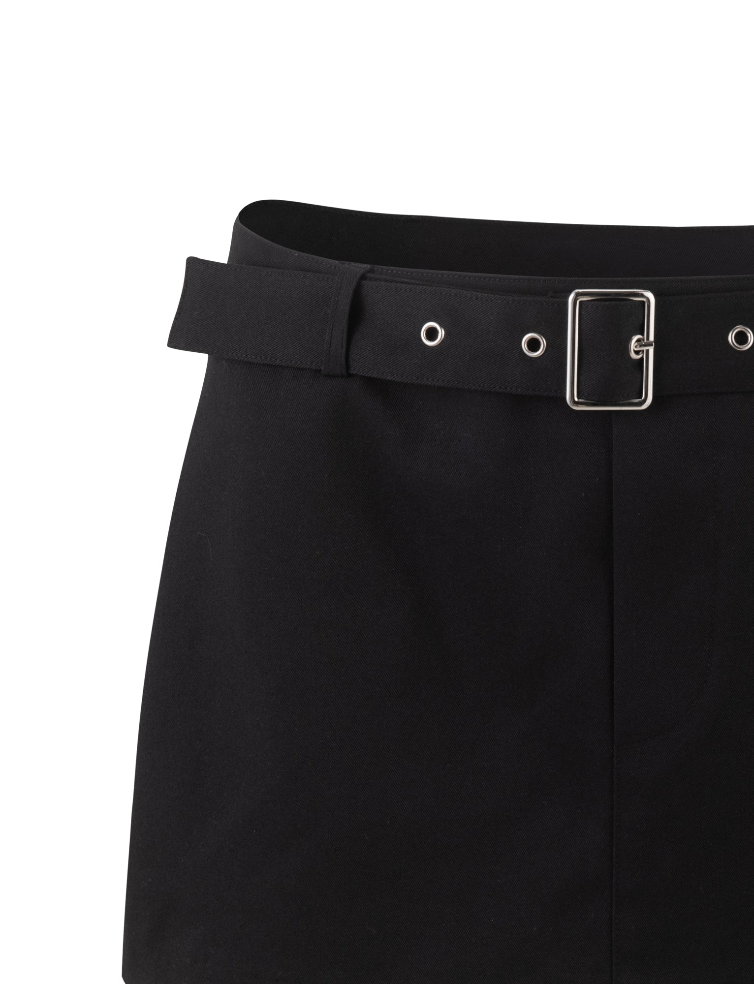 The NADINE SKORT by TIGERMIST is a black high-waisted skirt that includes a matching black belt with silver buckle and eyelets. The material has a smooth appearance, and the belt loops around the entire waistband. There are no additional visible details or embellishments.